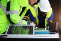 Two electrical engineers working with electronic circuit board and solar cells, mechanicals senior white and African American men