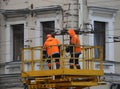 Two electrical workers in orange uniforms at work