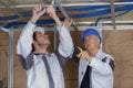 Two electricians repairing ceiling wiring Royalty Free Stock Photo