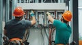 Two Electricians Working on an Electrical Panel in a Construction Site Royalty Free Stock Photo