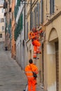 Two electricians working in uniforms and safety equipment in a street in Siena, Tuscany, Italy