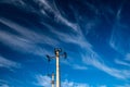 Two electricity pylons against dark blue sky with white clouds Royalty Free Stock Photo