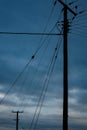 Two electricity pylons silhouetted underneath a cloudy sky Royalty Free Stock Photo