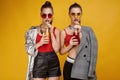 Two elegant glamor hipster twin girls in fashion red top with cocktail drink Royalty Free Stock Photo