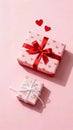 Two elegantly wrapped gift boxes adorned with heart patterns and ribbons set against a soft pink background with two small red Royalty Free Stock Photo