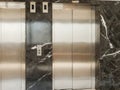 Two elevator doors stand in a building with dark marble walls. The setting shows a clean and modern environment for accessing Royalty Free Stock Photo