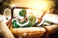 Two Elves in a car driving to deliver some christmas presents on a sunny winter day. Christmas decor on gold red background. Royalty Free Stock Photo
