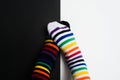 Two embarrassing legs in colorful striped socks on black and white background. Negative pair love concept with two people with Royalty Free Stock Photo