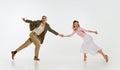 Two emotional dancers in vintage style clothes dancing swing dance, rock-and-roll or lindy hop isolated on white