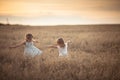 Two emotional sisters girls dance at sunset