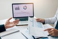 Two employees check the financial statements of the company together in the accounting room