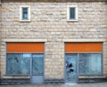 Empty abandoned shops on a street with whitewashed empty windows and blank store signs