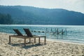 Two empty beach chairs and umbrella at a beach in Koh Kood, Thailand. Amazing scenery, relaxing beach, tropical landscape Royalty Free Stock Photo