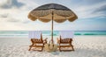 Two empty beach chairs under a decorative umbrella on a sandy shore Royalty Free Stock Photo