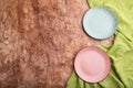 Two empty blue and pink plates on brown concrete background and green textile. Top view, copy space Royalty Free Stock Photo