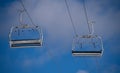 Two Empty Chairs on Ski Chair Lift on Blue Sky day Royalty Free Stock Photo