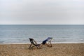 Two empty deckchairs on deserted shingle beach