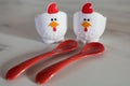 Two empty eggcups looking like a chicken with red spoons Royalty Free Stock Photo