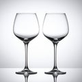 Two Empty Elegant Clear Wine Glasses on Reflective Surface against White Backdrop Royalty Free Stock Photo
