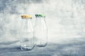 Two empty glass bottles with colorful lid on grey background. Copy space