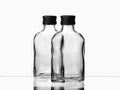 Two empty glass russian vodka bottle with black cap isolated on a white background Royalty Free Stock Photo