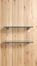 Two empty modern glass shelves mounted on a vertical light wood panel wall background for product display. Royalty Free Stock Photo