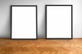 Two empty picture frames on wooden parquet floor white wall background , blank frame