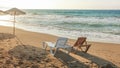 Two empty plastic sunbeds facing the sunset, sea in background. Image illustrating tropical vacation Royalty Free Stock Photo