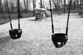 Two empty swings at the playground in the park. Royalty Free Stock Photo