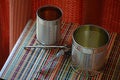 Two empty tin cans with an opener. Royalty Free Stock Photo