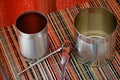 Two empty tin cans with an opener. Royalty Free Stock Photo