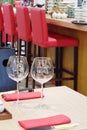 Two empty transparent wine glasses stand at table