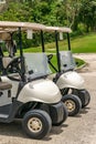 Two empty white golf carts parked side by side