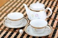 Two empty white porcelain cup and teapot on the table covered with striped table mat Royalty Free Stock Photo