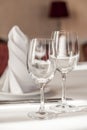 Two empty wine glasses on a served table. White tablecloth, glasses, appliances, red furniture Royalty Free Stock Photo