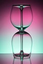 Two empty wineglass for red wine on diffusion lit background in abstract composition with reflection