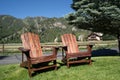 Two empty wood adirondack chairs sit on grass, overlooking the Sawtooth mountains of Idaho. Taken in Ketchum, ID Royalty Free Stock Photo