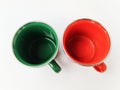 Two enameled cups in green and orange colors on a white background.