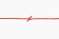 The two ends of a red rope are tied into a knot on a white isolated background Royalty Free Stock Photo