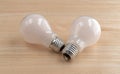 Two energy saving light bulbs on a wood table Royalty Free Stock Photo