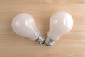 Two energy saving light bulbs on a wood table Royalty Free Stock Photo