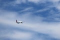 Airplane flying in the blue sky on background of white clouds, rear view Royalty Free Stock Photo