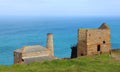 Engine houses on the green cliff edge above a blue sea at Levant copper and tin mine in Cornwall, England