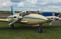 The two engine plane stands on the green grass in a cloudy day. A small private airfield in Zhytomyr, Ukraine