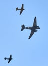 US Airforce plane dropping parachutists escorted by two vintage Dutch combat airplanes