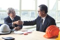 two engineer construction business man shaking hand after project solution meeting successful in office meeting room