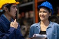 Two engineer or manager wearing safety helmet standing in the automotive part warehouse. Woman looking at man and smile. Team work Royalty Free Stock Photo
