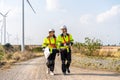 Two engineers caucasian man and woman in hardhat and goggles talk about system installation and walking to verify that a wind