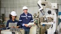 The two engineers check the operation of welding robots