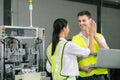 Two engineers clap together in an industrial warehouse. Large machinery Royalty Free Stock Photo